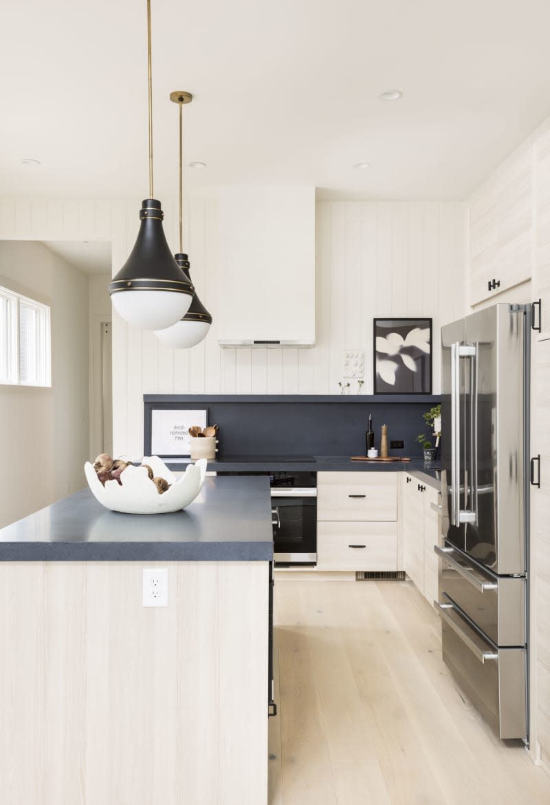 <span>“We kept the cabinetry light but textural with Oat Slab cabinetry from <a href="https://boxibysemihandmade.com/" rel="nofollow noopener" target="_blank" data-ylk="slk:BOXI;elm:context_link;itc:0;sec:content-canvas" class="link ">BOXI</a>. We integrated a tall pantry and worked to capture as much storage as possible so we could forgo wall cabinets” Courtney says. An inky-blue countertop (<a href="https://www.wilsonart.com/hidden-space" rel="nofollow noopener" target="_blank" data-ylk="slk:Hidden Space by Wilsonart;elm:context_link;itc:0;sec:content-canvas" class="link ">Hidden Space by Wilsonart</a>) adds a dose of drama. “To us, the cherry on top was the shallow-depth shelf we incorporated out of the same countertop material to hold artwork and small pieces of pottery.” Credit: <a href="https://www.jonasjungblutphoto.com/" rel="nofollow noopener" target="_blank" data-ylk="slk:Jonas Jungblut;elm:context_link;itc:0;sec:content-canvas" class="link ">Jonas Jungblut</a></span> <span class="copyright">Credit: <a href="https://www.jonasjungblutphoto.com/" rel="nofollow noopener" target="_blank" data-ylk="slk:Jonas Jungblut;elm:context_link;itc:0;sec:content-canvas" class="link ">Jonas Jungblut</a></span>