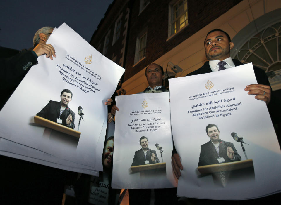 FILE - In this Tuesday, Nov. 12, 2013 file photo, demonstrators hold placards with pictures of Al-Jazeera Arabic network journalist Abdullah Al Shami who along with cameraman Mohamed Badr remain in custody in Egypt, during a protest calling for their release, outside Egypt's embassy in London. Egypt’s chief prosecutor has referred 20 journalists who work for the Qatar-based Al-Jazeera network, including four foreigners, to a criminal trial on charges of joining or assisting a terrorist group and spreading false news that endangers national security. Egypt's interim-backed military government accuses the Qatar-based broadcaster of being biased in favor of the Muslim Brotherhood, which authorities have branded a terrorist organization. Only eight are currently in detention. (AP Photo/Lefteris Pitarakis, File)