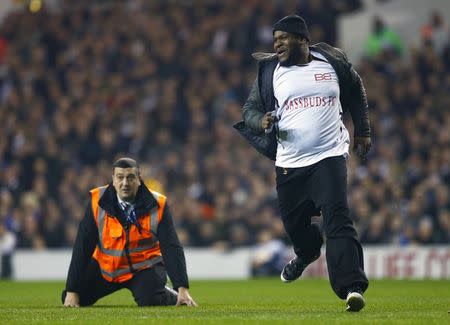 A steward falls over as he tries to catch a spectator that had run onto the pitch during the Europa League soccer match between Tottenham Hotspur' and Partizan Belgrade at White Hart Lane in London November 27, 2014. REUTERS/Eddie Keogh