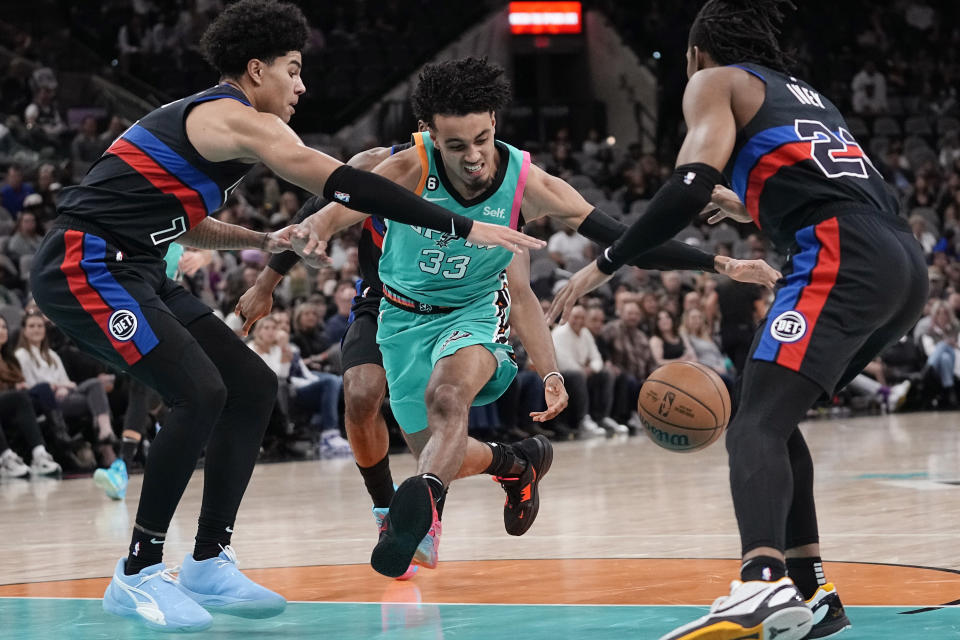 San Antonio Spurs guard Tre Jones (33) drives between Detroit Pistons guard Killian Hayes (7) and guard Jaden Ivey during the first half of an NBA basketball game in San Antonio, Friday, Jan. 6, 2023. (AP Photo/Eric Gay)