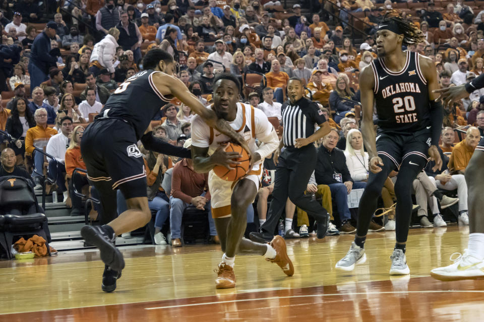 Oklahoma State guard Rondel Walker, left, ties up the ball against Texas guard Courtney Ramey, right, during the first half of an NCAA college basketball game, Saturday, Jan. 22, 2022, in Austin, Texas. Texas won 56-51. (AP Photo/Michael Thomas)