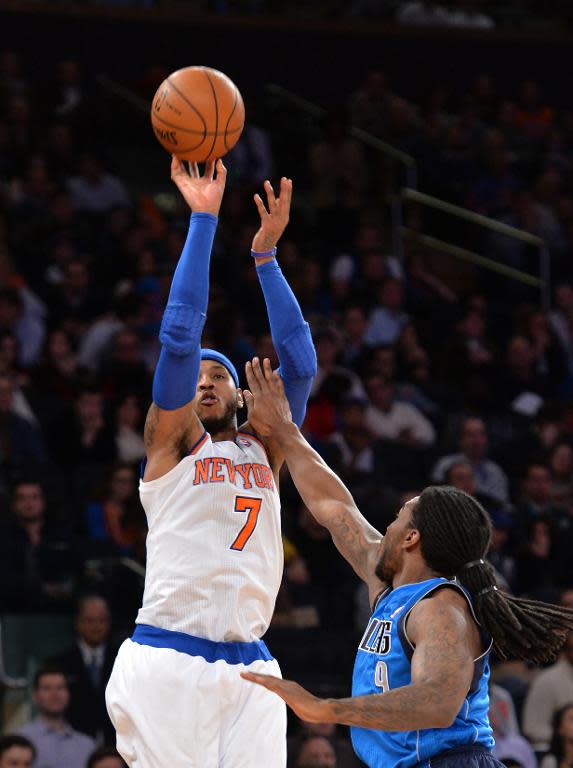 Carmelo Anthony of the New York Knicks (L) shoots over Jae Crowder of the Dallas Mavericks during their NBA game on February 24, 2014 at Madison Square Garden in New York