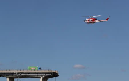 Firefighter helicopter flies over the collapsed Morandi Bridge in the Italian port city of Genoa, Italy August 15, 2018. REUTERS/Stefano Rellandini