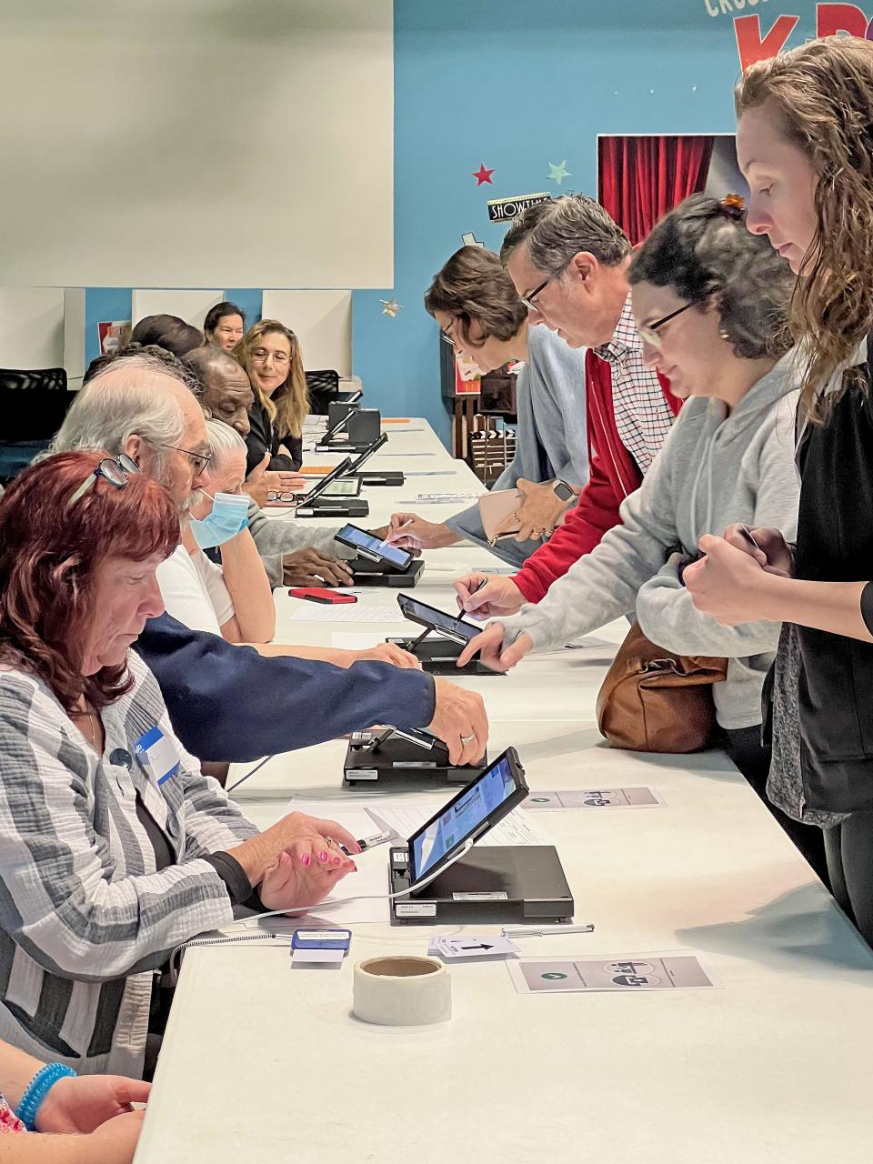 Poll workers help prepare voters to cast their ballots Tuesday morning at Crossroads Community Church.