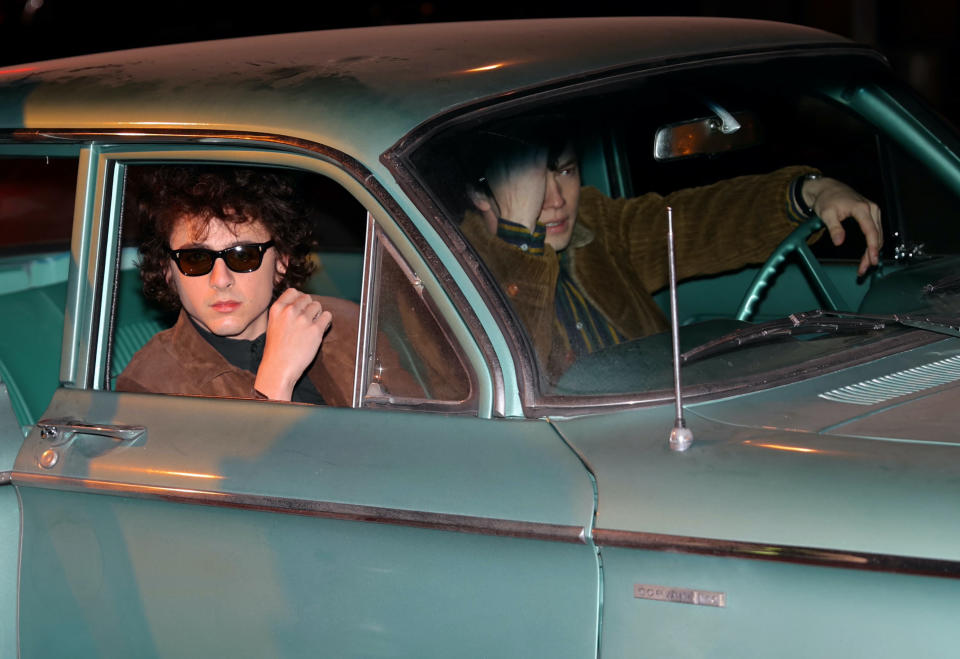 The two actors in a vintage car, Timmy wearing sunglasses, and another man in the driver's seat