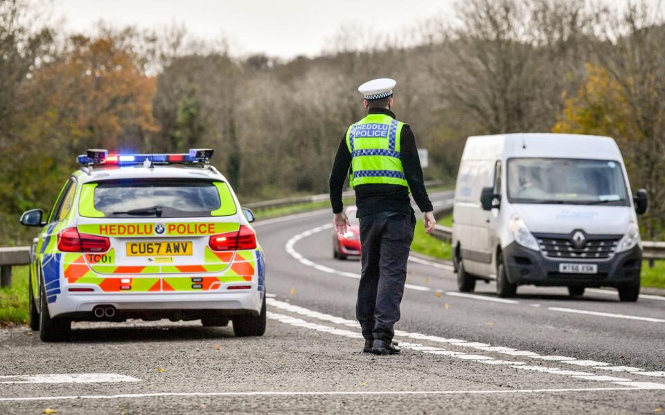 Welsh police pull over cars at a checkpoint during firebrake vehicle patrols close to the border between Camarthenshire and Pembrokeshire, Wale - Ben Birchall /PA