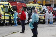 FILE - In this Jan. 22, 2021, file photo, ambulance personnel stand waiting as more than a dozen ambulances queue waiting to hand over their COVID-19 patients to medics at the Santa Maria hospital in Lisbon. In its fight against COVID-19, Portugal lifted restrictions on gatherings and movements for four days over Christmas so that people could spend the festive season with family and friends. Soon after the holiday, the pandemic quickly got out of hand. (AP Photo/Armando Franca, File)