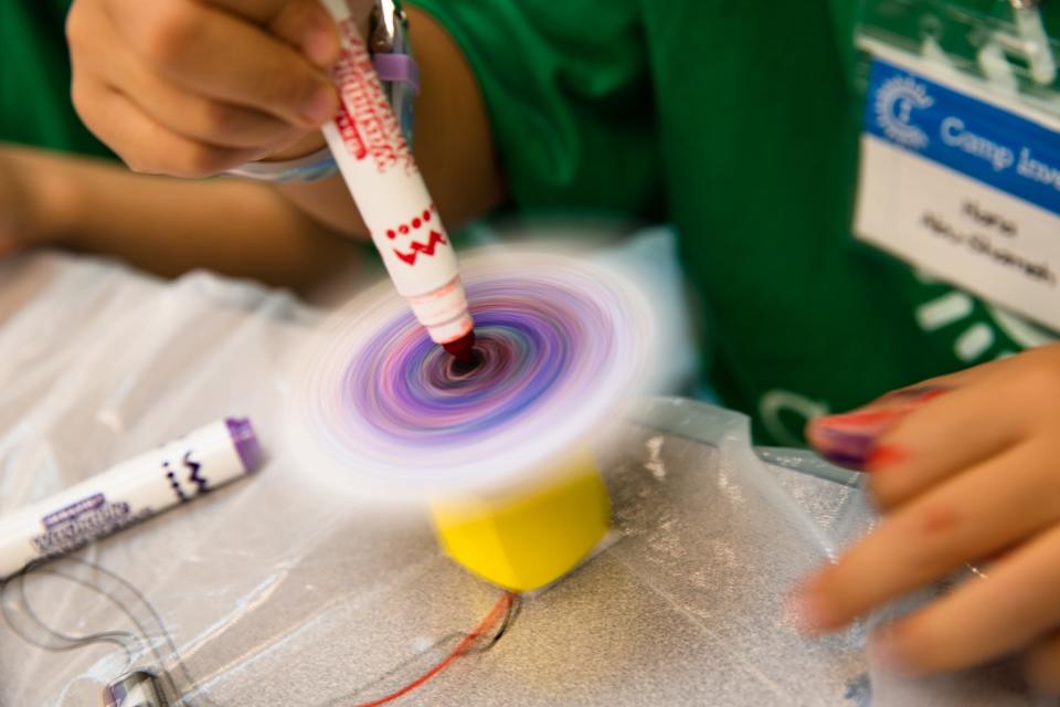 Hana Abu-Shameh uses a battery-powered spinner to create art at Camp Invention at Windsor Park Elementary School on Thursday, June 16, 2022.