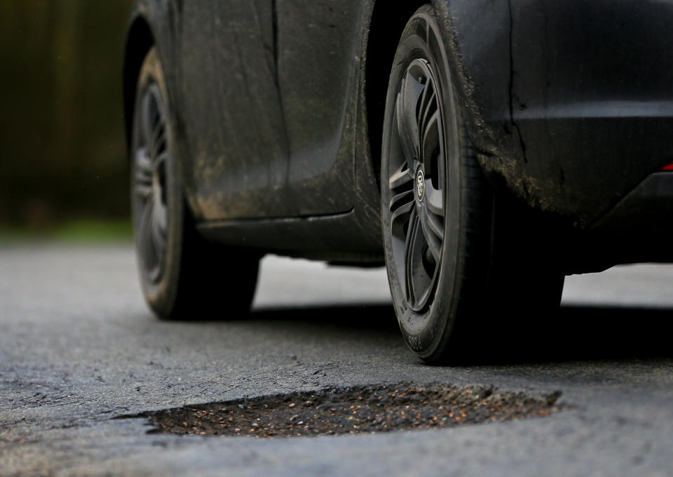 A car passes a pothole in Ashford in Kent. One in five local roads is in a poor condition as councils face a huge funding deficit to tackle potholes, according to a new report. (Photo by Gareth Fuller/PA Images via Getty Images)