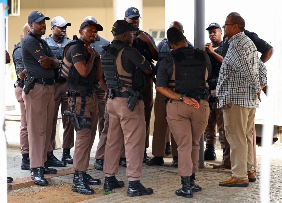 Correctional service emergency support team members look on at the entrance of the National head offices of the correctional services, where parolees are processed (Reuters)