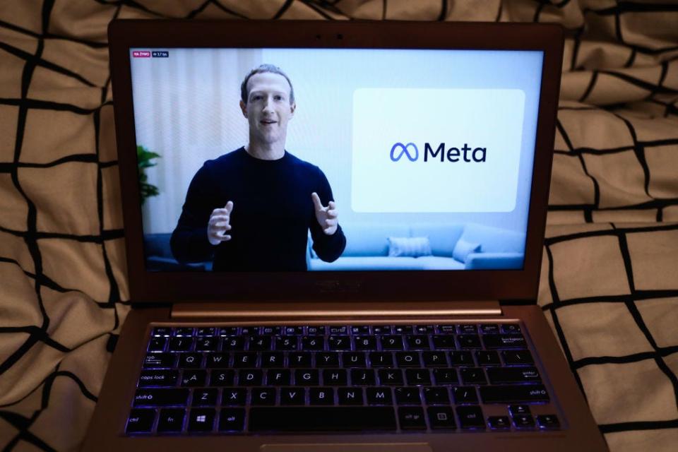 Mark Zuckerberg announcing the new name of the company and Meta logo are seen during Facebook Connect livestream displayed on a laptop screen