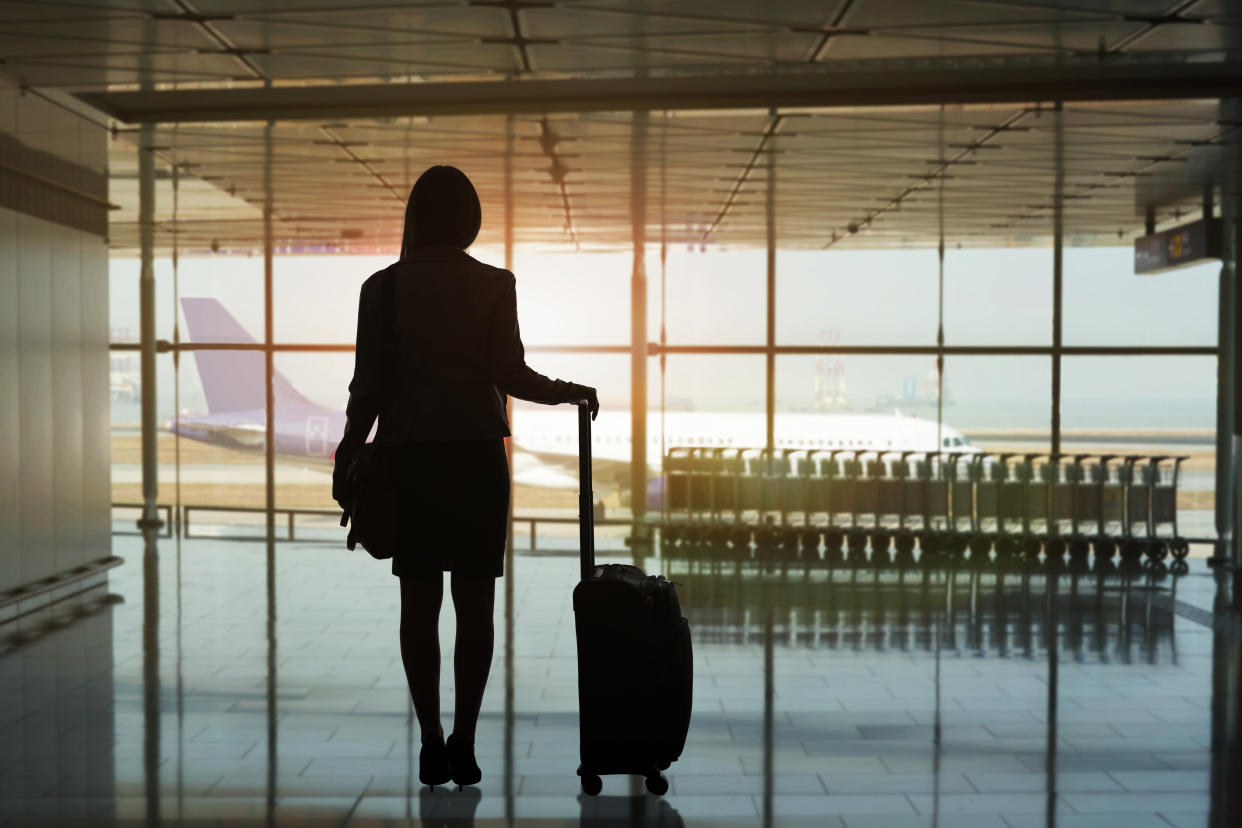 Silhouette of a woman traveller waiting for her flight at Hong Kong International Airport.