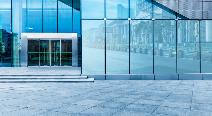 buildings and clean road reflected on the glass wall