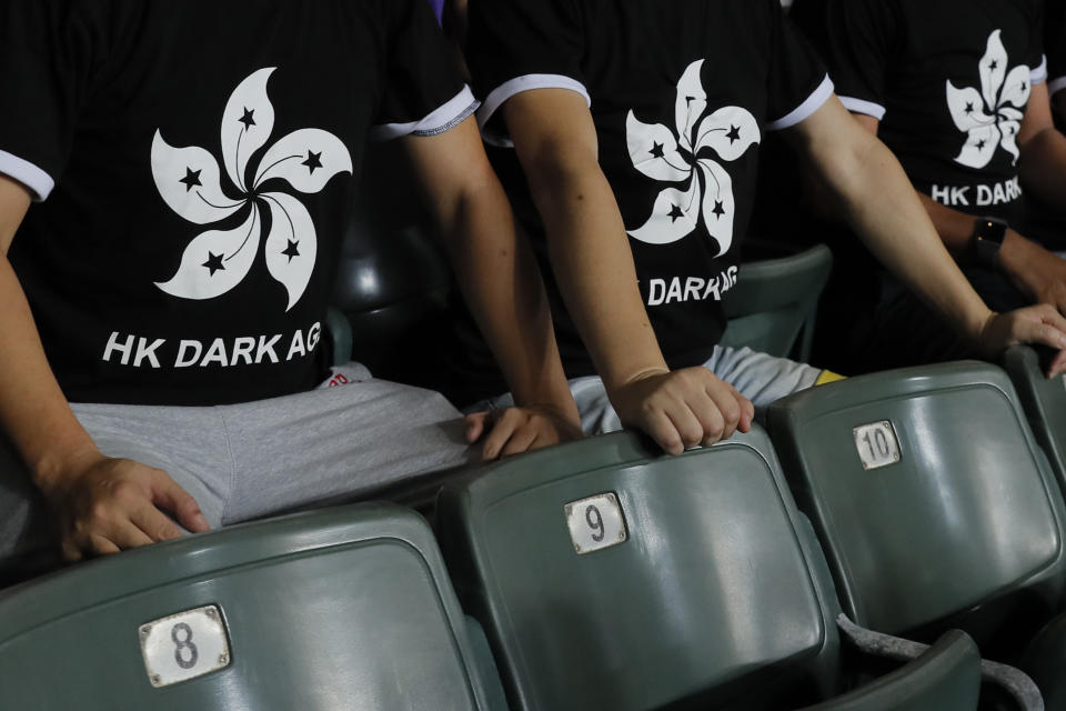 Hong Kong soccer fans wear T-shirt featuring black version of the Hong Kong flags to protest against government during the FIFA World Cup Qatar 2022 and AFC Asian Cup 2023 Preliminary Joint Qualification Round 2 soccer match between Hong Kong and Iran, in Hong Kong, Tuesday, Sept. 10, 2019. The crowd broke out into "Glory to Hong Kong," a song reflecting their campaign for more democratic freedoms in the semi-autonomous Chinese territory. (AP Photo/Kin Cheung)