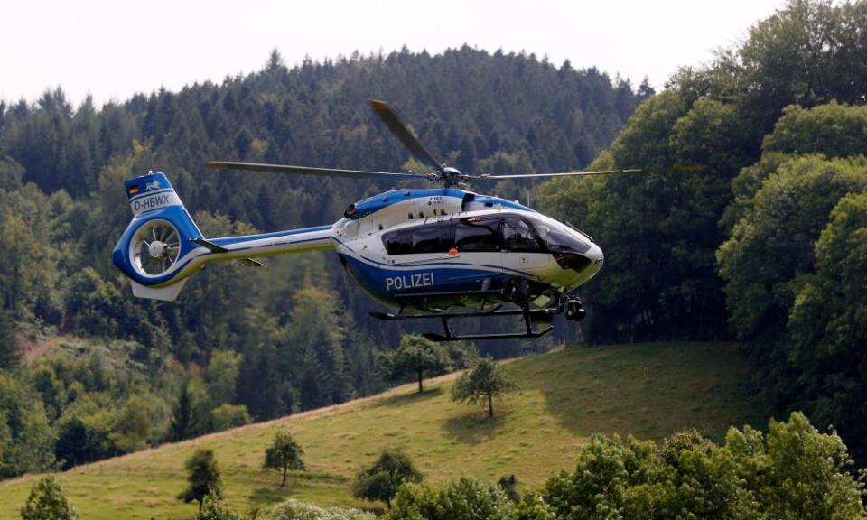 A police helicopter flies over a forest area north of Oppenau, Germany, as part of the search.