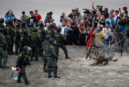 Faith leaders gather in support of the migrant caravan in front of U.S. Customs and Border Protection (CBP) officials, at the border fence between the United States and Mexico, as seen from Tijuana, Mexico December 10, 2018. REUTERS/Carlos Garcia Rawlins