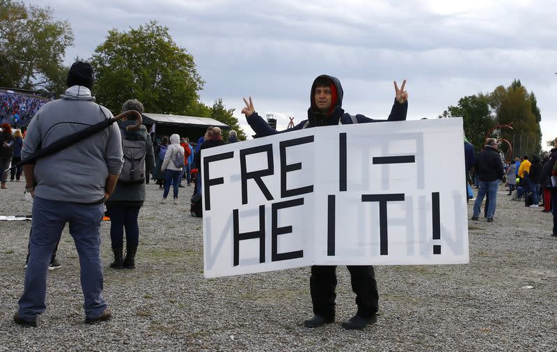 Man displays a poster during a protest against the government's restrictions in Konstanz