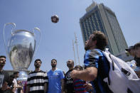 Soccer fans gather near a giant Champions League trophy shaped balloon, left, at Taksim square in Istanbul, Turkey, Saturday, June 10, 2023 ahead of the Champions League final soccer match between Manchester City and Inter Milan. (AP Photo/Khalil Hamra)