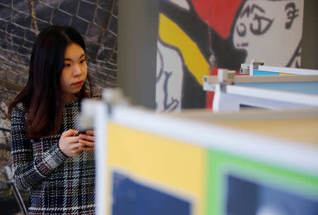 A woman plays the game "Wallpeckers - from the DMZ to the Berlin Wall" before the official launch at the visitor center of the Berlin wall memorial in Berlin, Germany, January 17, 2019. REUTERS/Hannibal Hanschke