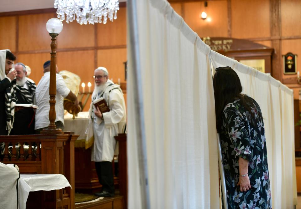 WORCESTER - Chani Fogelman, whose husband is Rabbi Fogelman, peers through a partition on the women's side of the synagogue during a Rosh Hashanah service at Chabad Lubavitch of Central Massachusetts, marking the beginning of the Jewish New Year and High Holy Days leading to Yom Kippur, Monday, Sept. 26, 2022.