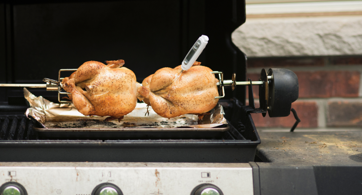two roast chickens on bbq with white meat thermometer inside