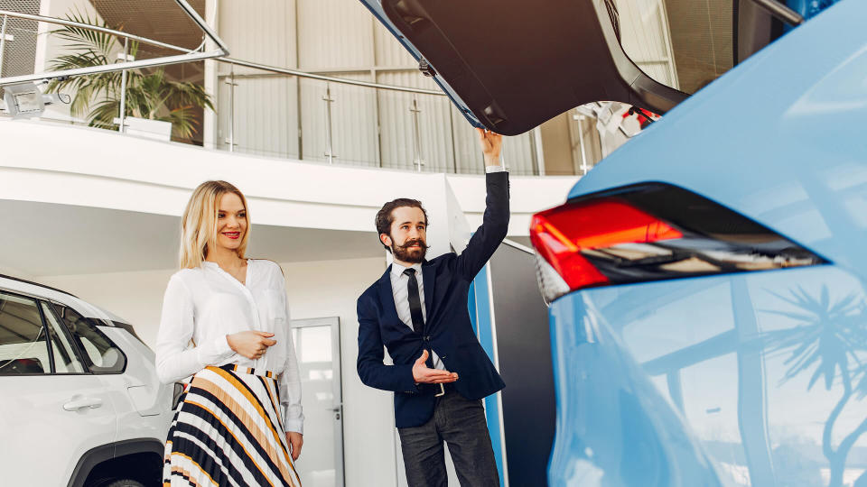 woman checking out car in dealership