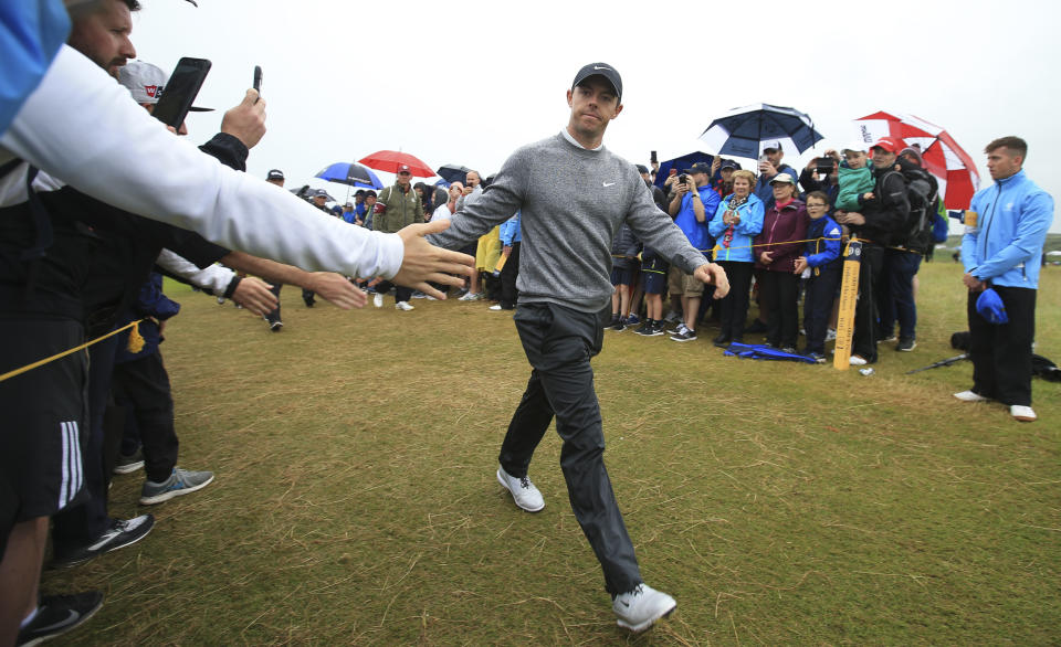 Northern Ireland's Rory McIlroy touches hands with spectators as he walks to the 2nd tee during the second round of the British Open Golf Championships at Royal Portrush in Northern Ireland, Friday, July 19, 2019.(AP Photo/Jon Super)