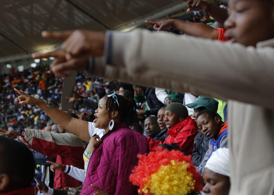 People sing songs during the memorial service for former South African president Nelson Mandela at the FNB Stadium in Soweto near Johannesburg, Tuesday, Dec. 10, 2013. (AP Photo/Markus Schreiber)