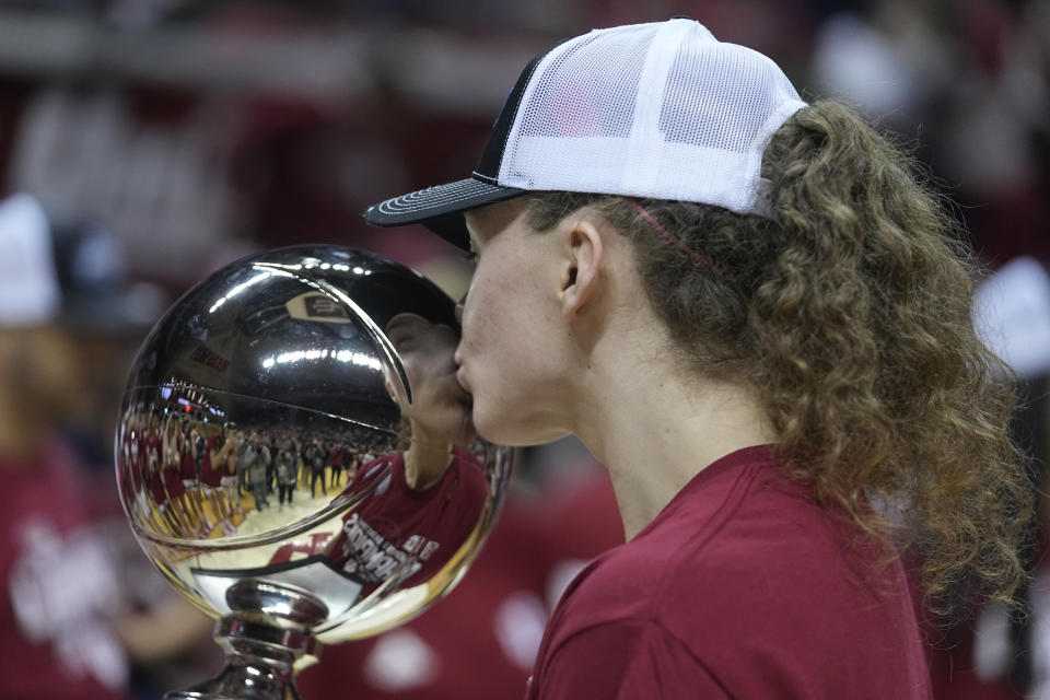 Indiana's Grace Berger kisses the trophy after her team defeated Purdue in an NCAA college basketball game, Sunday, Feb. 19, 2023, in Bloomington, Ind. (AP Photo/Darron Cummings)
