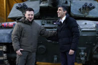 British Prime Minister Rishi Sunak, right, and Ukrainian President Volodymyr Zelensky meet Ukrainian troops being trained to command Challenger 2 tanks at a military facility in Lulworth, Dorset, England, Wednesday Feb. 8, 2023. (Andrew Matthews/Pool via AP)