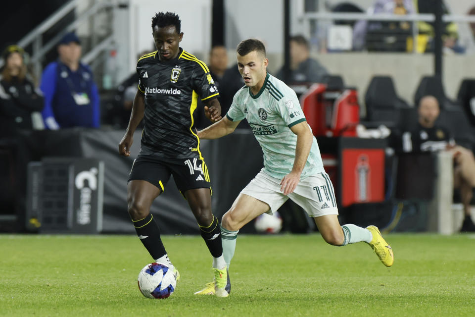 Columbus Crew's Yaw Yeboah, left, and Atlanta United's Brooks Lennon chase the ball during the first half of an MLS playoff soccer match Sunday, Nov. 12, 2023, in Columbus, Ohio. (AP Photo/Jay LaPrete)