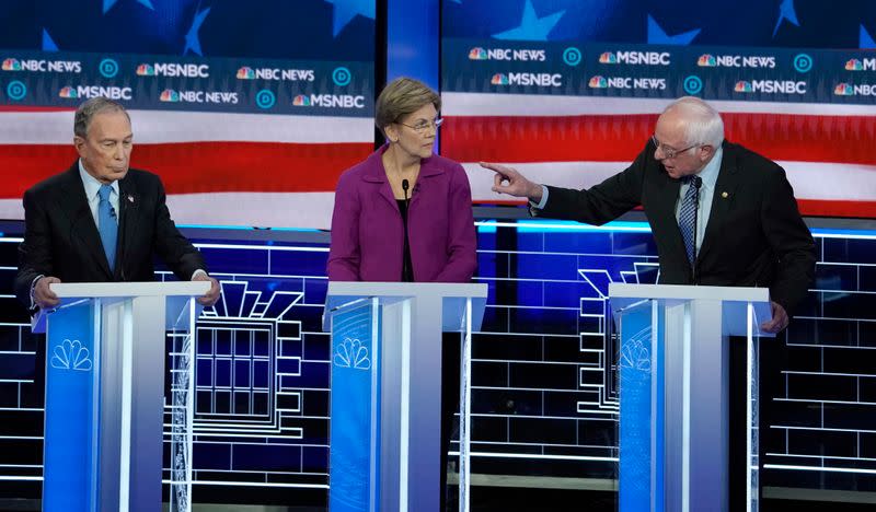 Bernie Sanders speaks to Michael Bloomberg about the non-disclosure agreements at Bloomberg's company as Senator Elizabeth Warren listens at the ninth Democratic 2020 U.S. Presidential candidates debate at the Paris Theater in Las Vegas