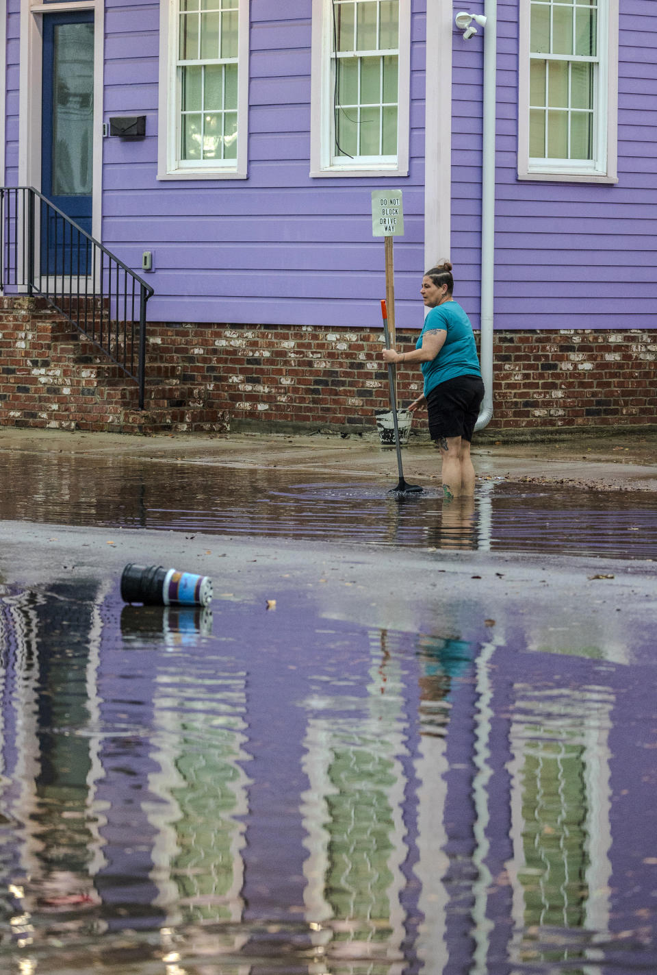 Crystal Hilgado uses a broom to clean out the drain on her street near downtown New Orleans on Wednesday, April 10, 2024. Severe thunderstorms were expected across parts of the Louisiana, Mississippi, Alabama and the Florida panhandle and there was the potential for tornadoes, a few of which may be strong, and damaging winds, which may exceed 75 mph (120 kph), the National Weather Service warned.(Chris Granger /The Times-Picayune/The New Orleans Advocate via AP)