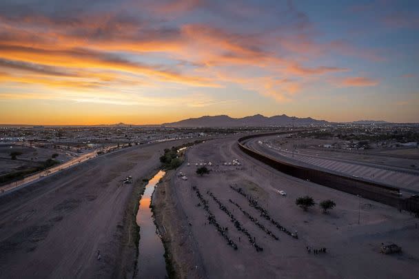 PHOTO: Immigrants wait near the U.S.-Mexico border fence after crossing the Rio Grande from Mexico on May 9, 2023, in El Paso, Texas. (John Moore/Getty Images)