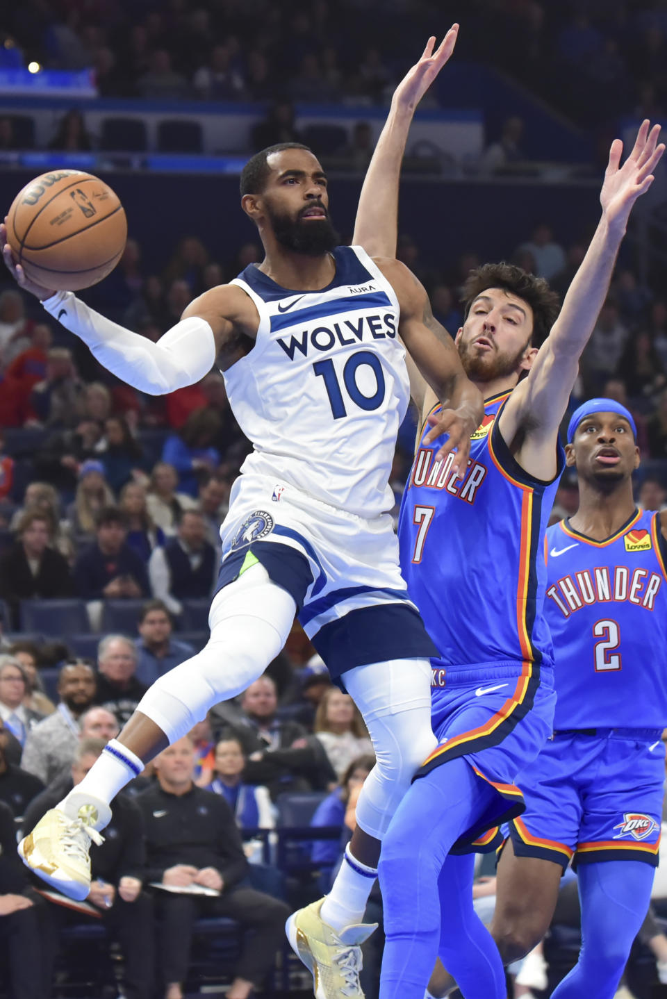 Minnesota Timberwolves guard Mike Conley (10) passes the ball past Oklahoma City Thunder forward Chet Holmgren (7) during the first half of an NBA basketball game Tuesday, Dec. 26, 2023, in Oklahoma City. (AP Photo/Kyle Phillips)