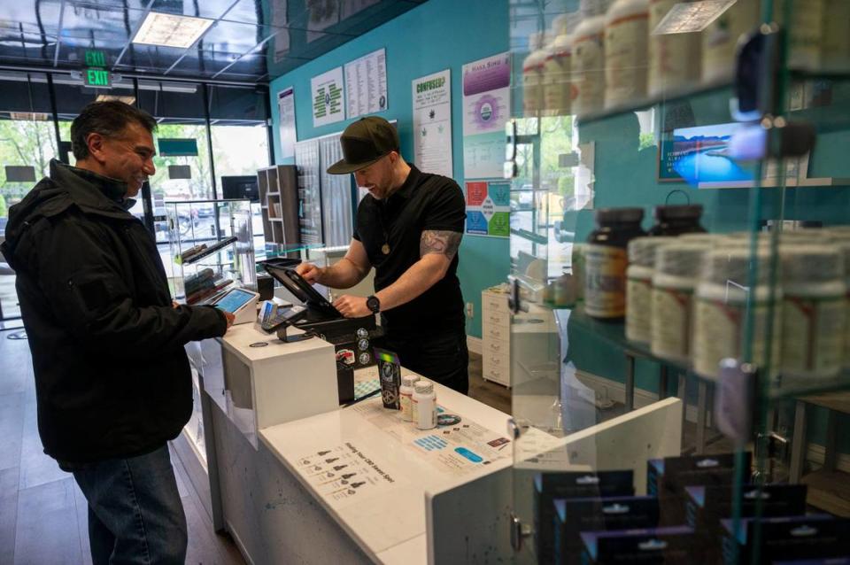 Aaron Grove, right, owner of Elk Grove CBD, helps customer Ray Tamayo on Saturday, April 13, 2024. Elk Grove prohibits marijuana dispensaries from operating in the city limits.