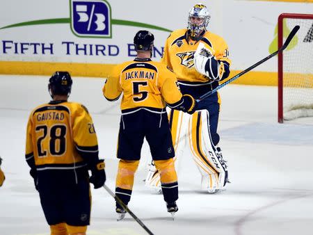 Nashville Predators goalie Pekka Rinne (35) celebrates with defenseman Barret Jackman (5) after a win against the San Jose Sharks in game three of the second round of the 2016 Stanley Cup Playoffs at Bridgestone Arena. The Predators won 4-1. Mandatory Credit: Christopher Hanewinckel-USA TODAY Sports