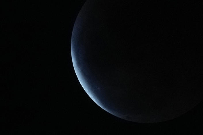 The earth's shadow covers the moon during a lunar eclipse in Metro Manila, Philippines, Tuesday, Nov. 8, 2022. (AP Photo/Aaron Favila)