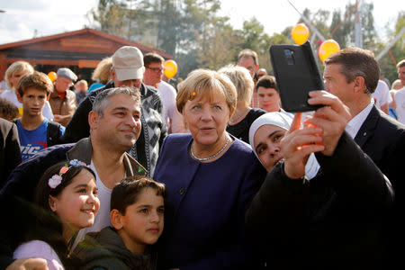 FILE PHOTO: German Chancellor Angela Merkel, a top candidate of the Christian Democratic Union Party (CDU) for the upcoming general elections poses for a selfie during an election rally in Stralsund, Germany September 16, 2017. REUTERS/Axel Schmidt/File Photo