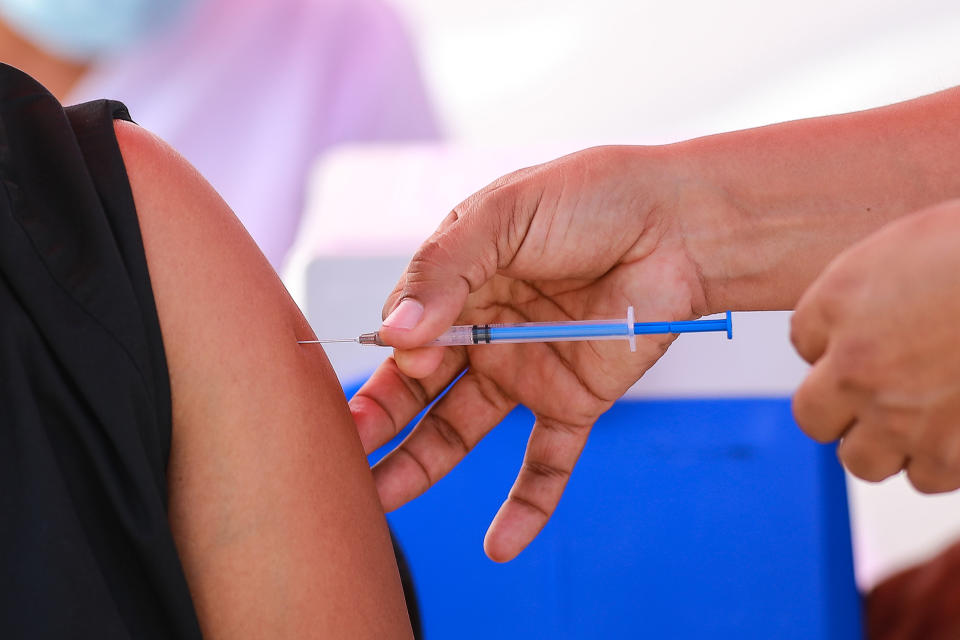 MEXICO CITY, MEXICO - DECEMBER 30: A nurse gives the Pfizer/BioNTech vaccine to a medical worker as part of Mexico COVID-19 vaccination plan at the Military Camp Number 1-A facilities on December 30, 2020 in Mexico City, Mexico. (Photo by Manuel Velasquez/Anadolu Agency via Getty Images)