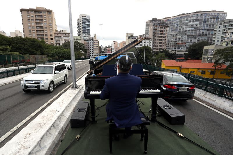 Pianist Rodrigo Cunha serenades from an open truck, in Sao Paulo