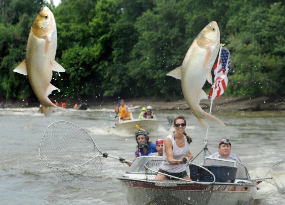 Participants try to snag Asian carp during the Redneck Fishing Tournament in Bath, Ill.