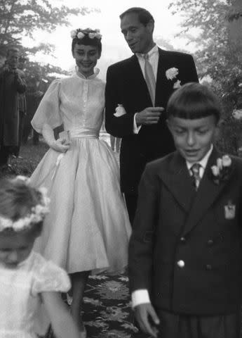 <p>Ernst Haas/Ernst Haas/Getty</p> Audrey Hepburn and Mel Ferrer walk arm in arm on their wedding day on September 25, 1954.