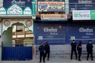 Nepalese police officers stand guard in front of a mosque as locals protest against Indonesians taking shelter at the mosque, amid fear of outsiders spreading coronavirus disease (COVID-19), at Jame Masjid in Imadol, Lalitpur