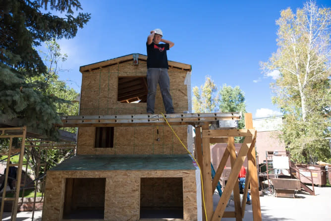 Ryley Benson adjusts his helmet while working on a tiny home.