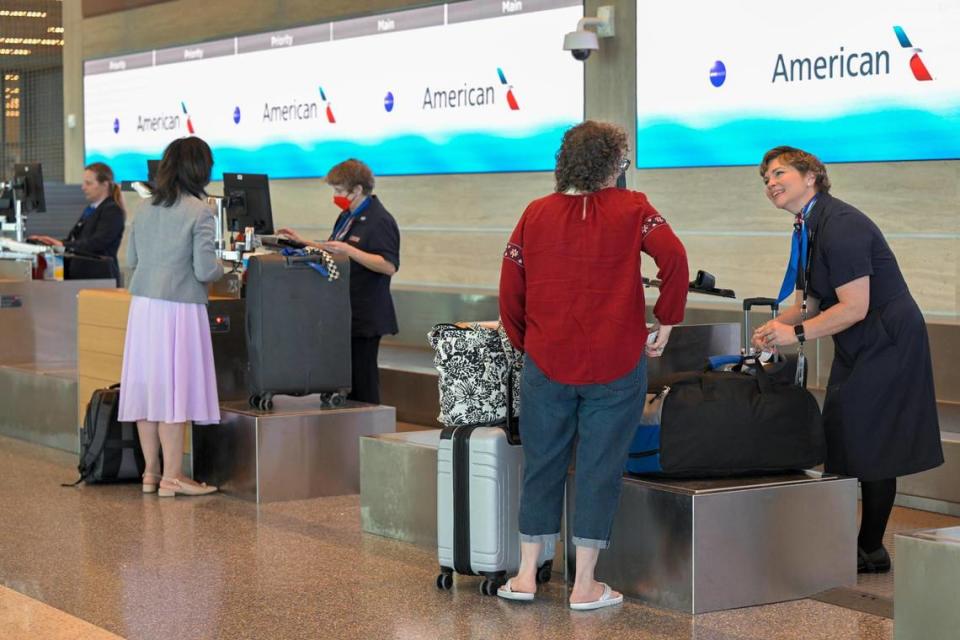 Cindy Fisher of Northfield, Mass., checks her bag in with American Airlines customer service agent Rachel Cady at Kansas City International Airport.