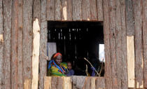 A Congolese mother, who fled from Democratic Republic of Congo by fleeing on a boat across Lake Albert, looks through a window as she carries her child at United Nations High Commission for Refugees' (UNHCR) Kyangwali refugee settlement camp, Uganda March 19, 2018. Picture taken March 19, 2018. REUTERS/James Akena