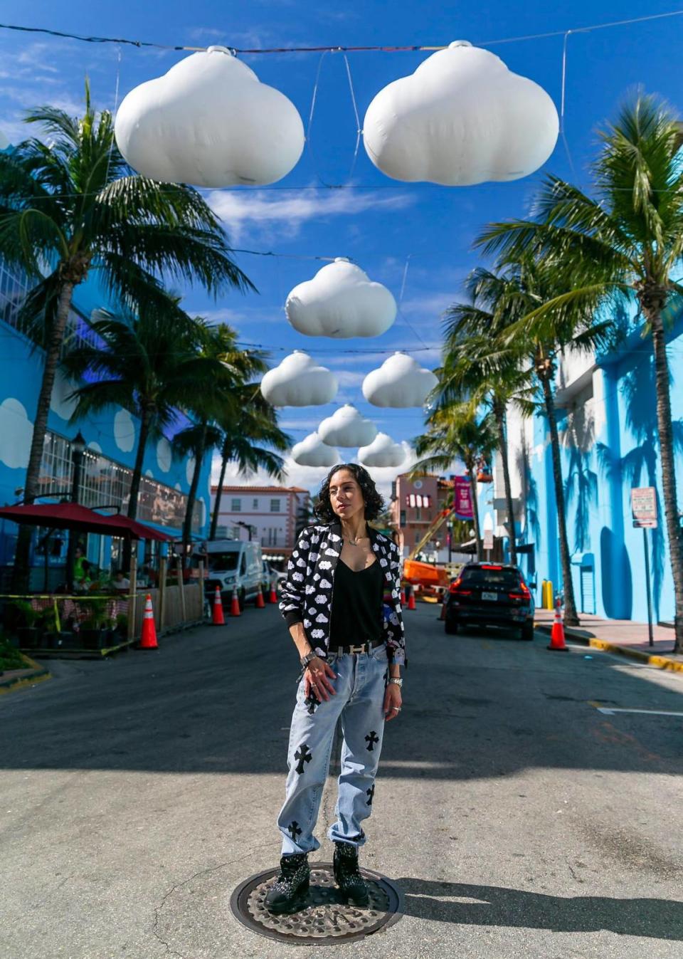 Lina Kandel, who is visiting from Denver, poses underneath Little Cloud Sky by FriendsWithYou on Miami Beach.