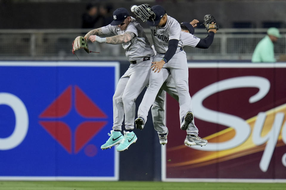 New York Yankees right fielder Juan Soto, center, celebrates with teammates left fielder Alex Verdugo, left, and center fielder Trent Grisham after the Yankees defeated the San Diego Padres 8-0 in a baseball game, Friday, May 24, 2024, in San Diego. (AP Photo/Gregory Bull)