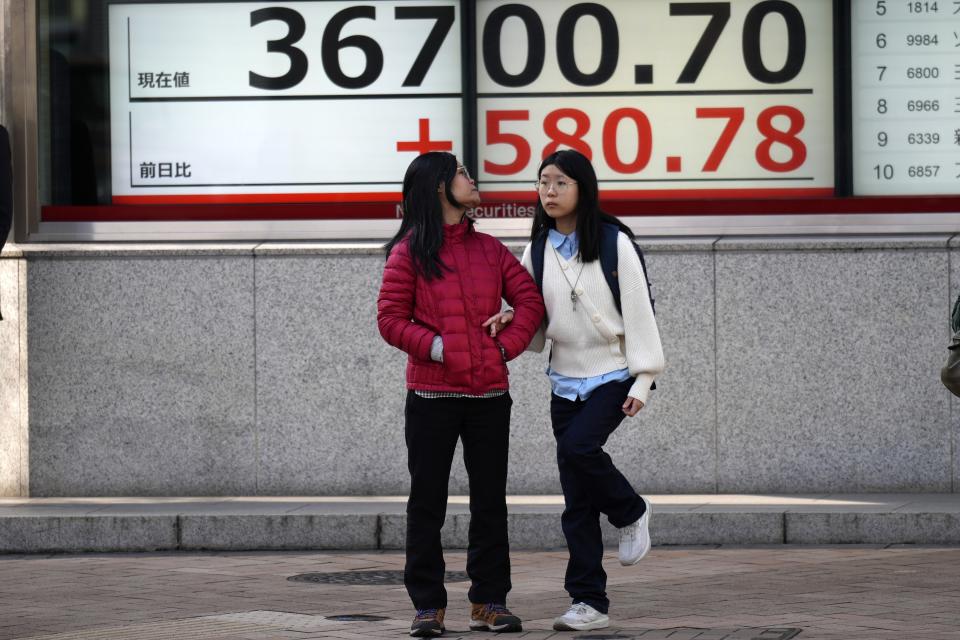 People stand in front of an electronic stock board showing Japan's Nikkei 225 index at a securities firm Thursday, Feb. 8, 2024, in Tokyo. (AP Photo/Eugene Hoshiko)